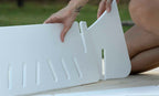 Close view of hands joining the white support panels of a pool chaise riser.