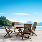 Bahama Classic five-piece teak dining set with round folding table and four armchairs in an outdoor mountain setting