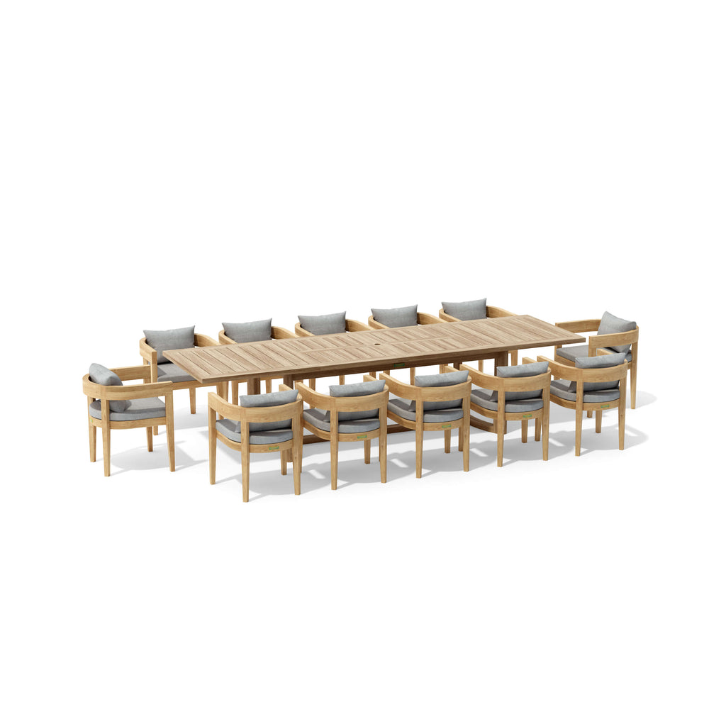 Angled view of the Coronado teak extension dining table with twelve cushioned armchairs.