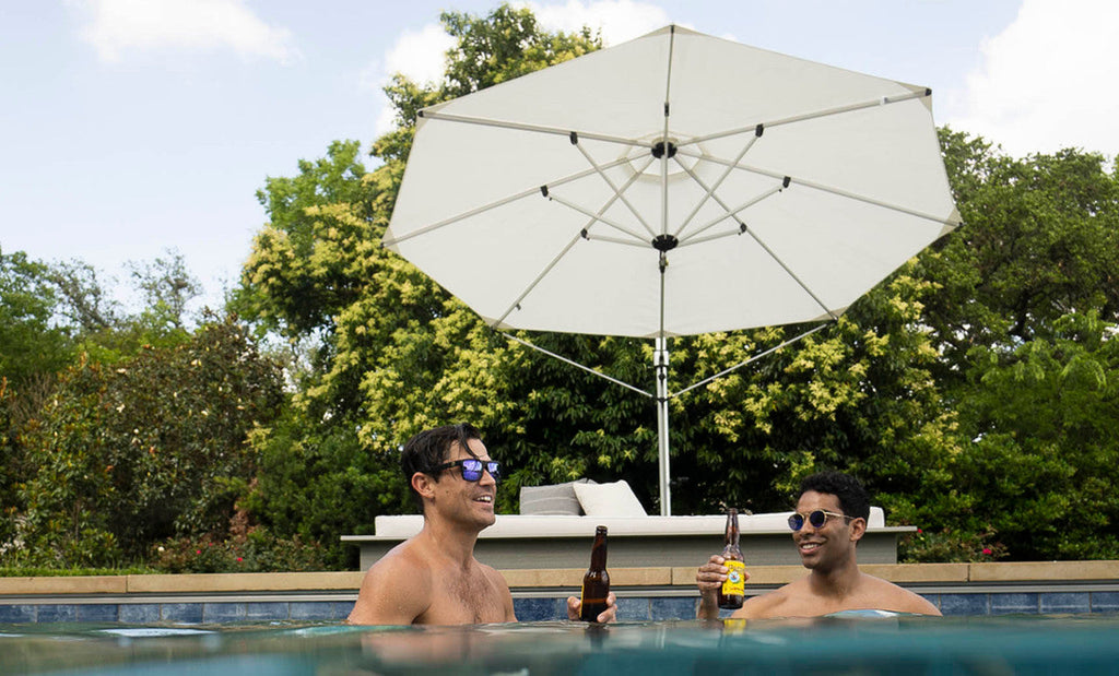 Ledge Lounger Ultra Cantilever Umbrella lifestyle, couple relaxing poolside in shade