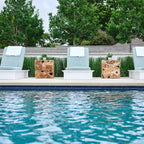 White Ledge Lounger Echo Chaises with blue-gray cushions arranged beside a pool with wood side tables.