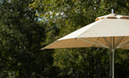 Linen 9-foot Premier Umbrella with polished aluminum pole in an outdoor setting