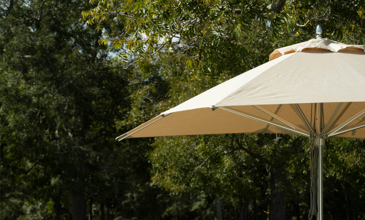 Linen 9-foot Premier Umbrella with polished aluminum pole in an outdoor setting