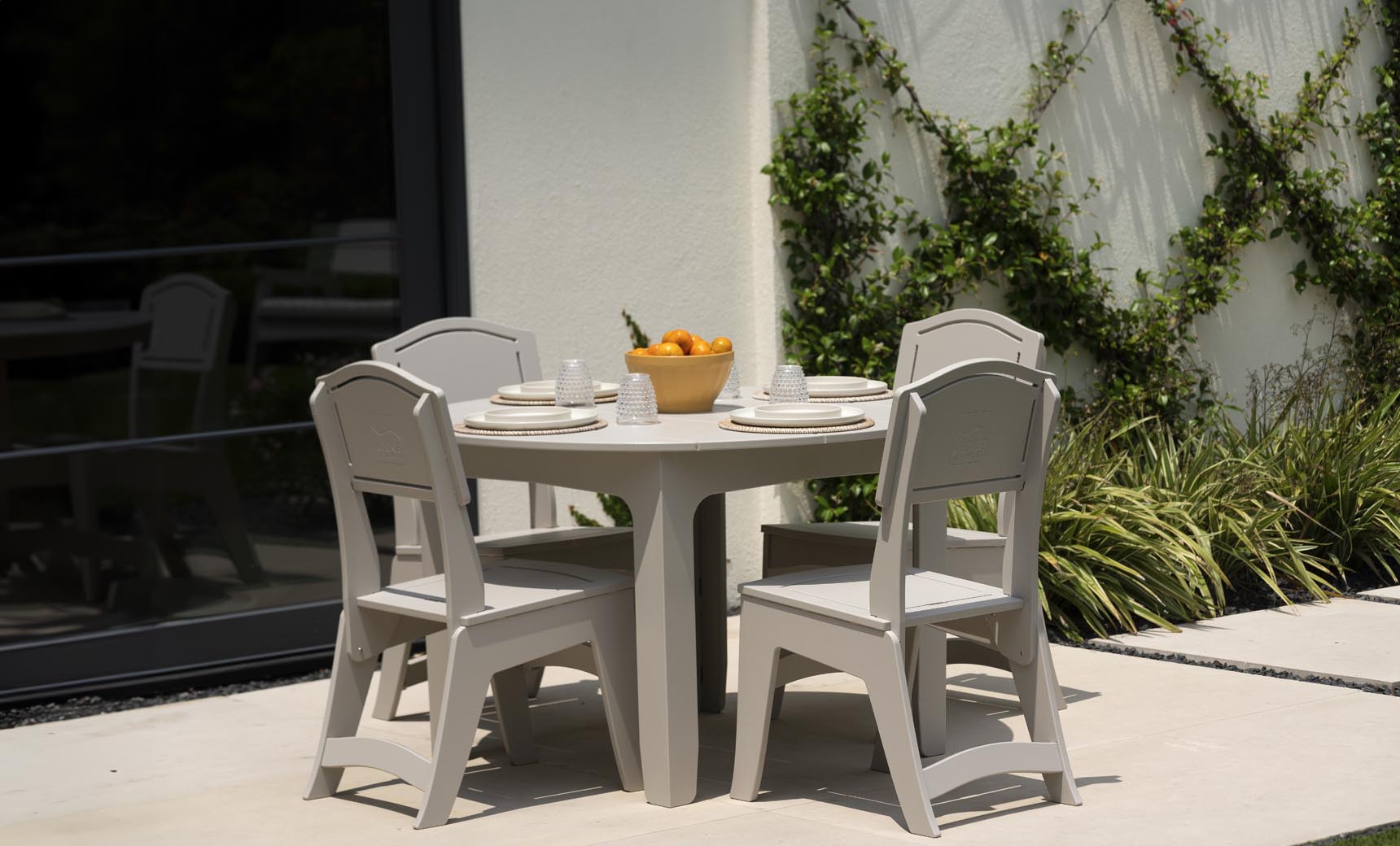 Ledge Lounger Mainstay Round Dining Table lifestyle, patio dining with chairs and place settings