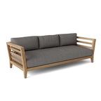 Front angled view of a teak outdoor sofa with gray seat and back cushions.