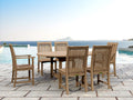Bahama Chicago oval teak extension dining table with six Chicago teak chairs on a stone pool deck overlooking the sea