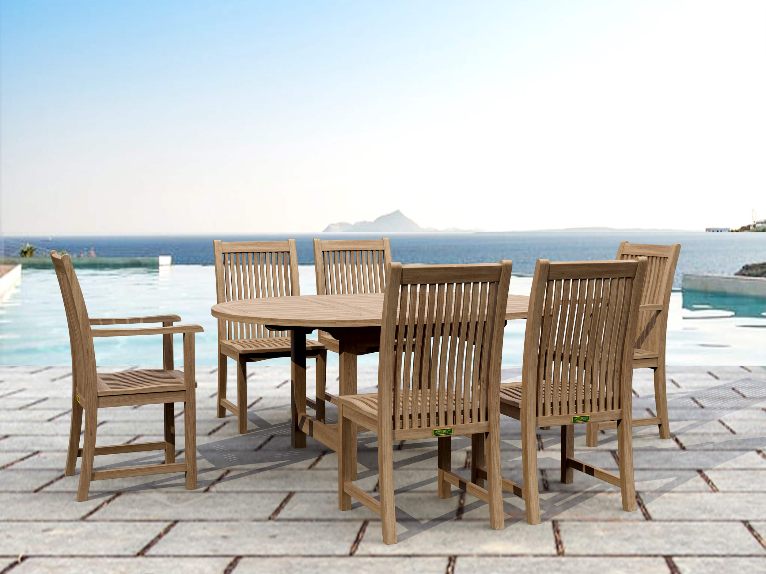 Bahama Chicago oval teak extension dining table with six Chicago teak chairs on a stone pool deck overlooking the sea