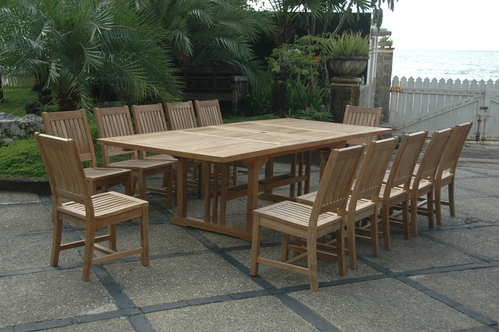 Sahara Rialto teak extension dining set with twelve armless chairs on a stone patio, showing the extended tabletop seams and center umbrella hole