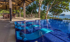 White Signature Chaise submerged on a tiled indoor pool ledge