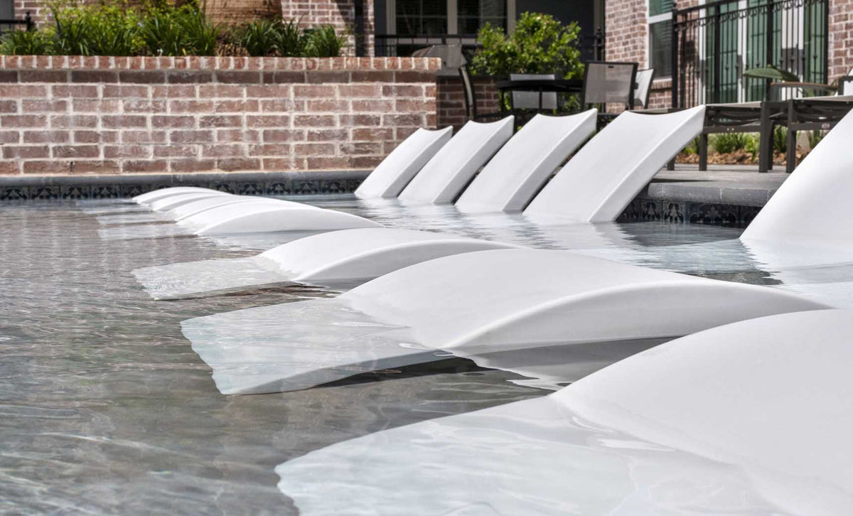 Row of White Signature Chaises on a commercial pool sun shelf