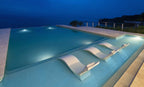 Signature Chaise Deep lifestyle in White at an infinity pool at dusk