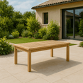 Montage rectangular teak outdoor coffee table on a stone patio beside a garden — Anderson Teak TB-4824CT