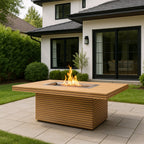 Three-quarter view of a teak fire table with flames on a modern house patio.