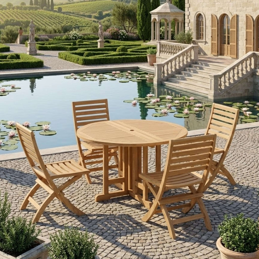 Andrew Butterfly round folding teak dining table and four chairs beside a formal garden pond