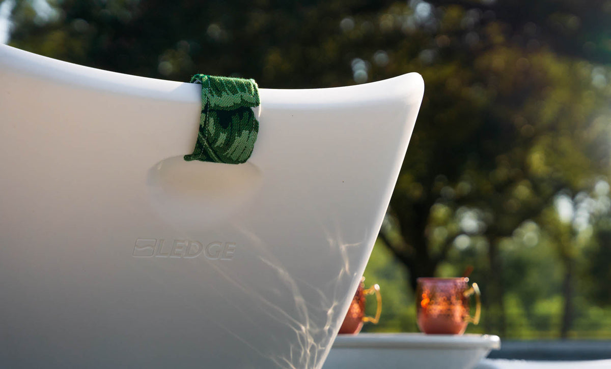 Autograph pillow strap clipped into the back recess of a white chaise