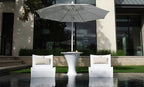 White in-pool umbrella stand with ice bin between two upright lounge chairs on a sun shelf.
