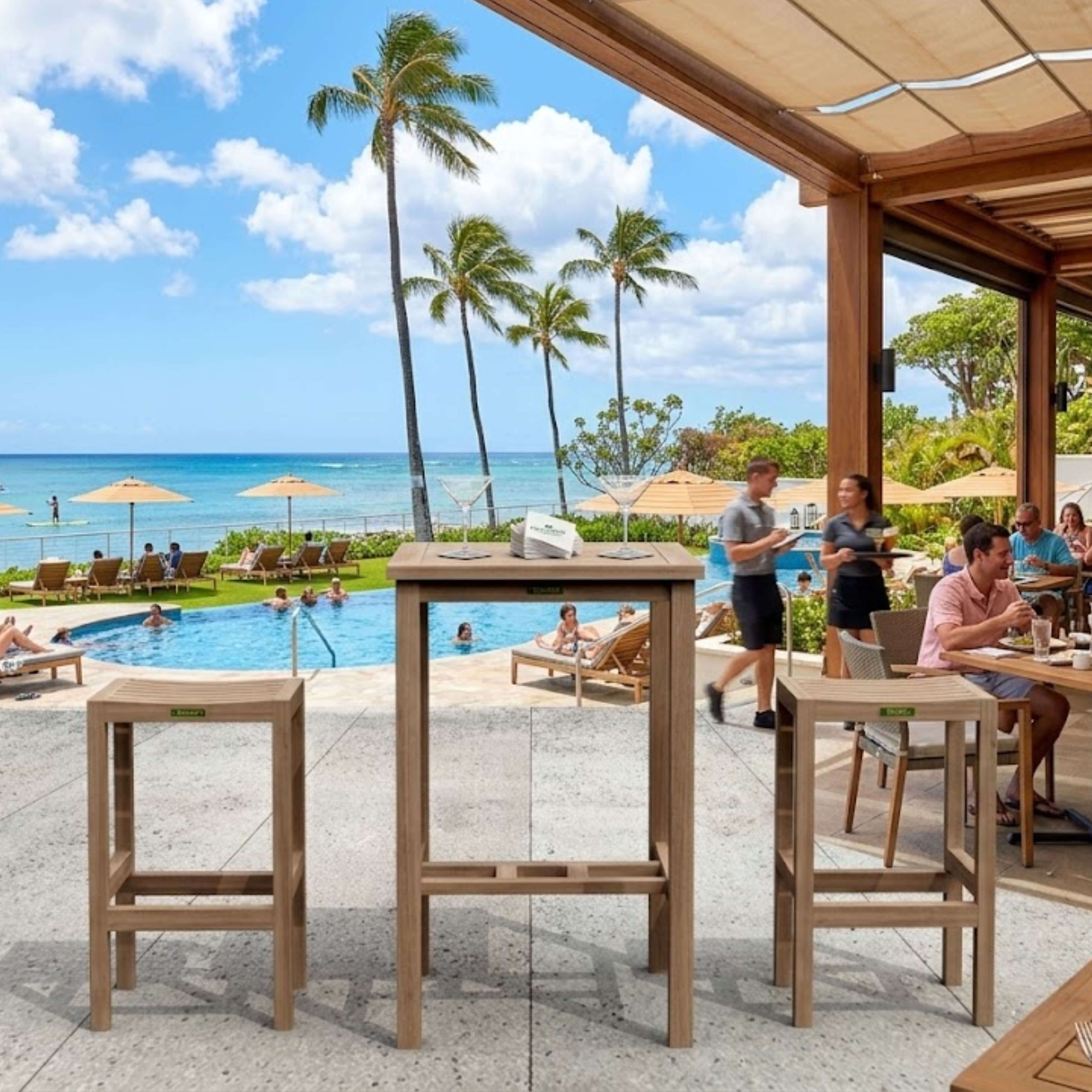 Avalon 3-piece teak bar set with two backless chairs overlooking a resort pool