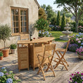 Altavista folding teak bar set with four chairs on a garden patio